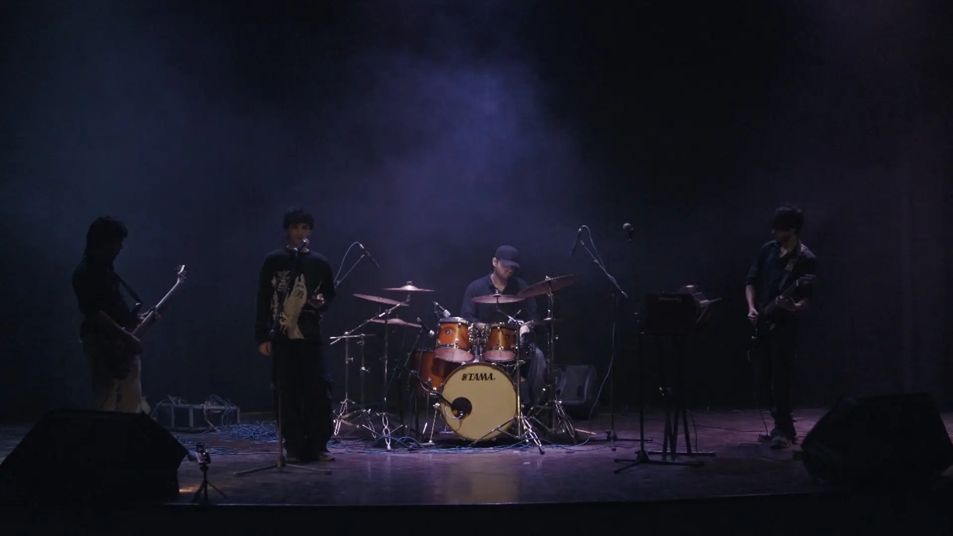 Khaak performs a live set on the Alhamra stage under stage light and haze